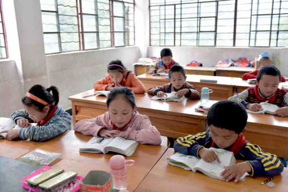 Students read at a primary school in the Gongshan Derung and Nu autonomous county, Yunnan province. The area is among the places suffering from extreme poverty to which educational funds will be diverted. (Photo: Xinhua/Yan Zongyou)