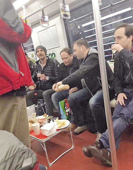 Foreigners enjoying a picnic on the Metro, complete with a table, food, drinks and plates — but no waiters.